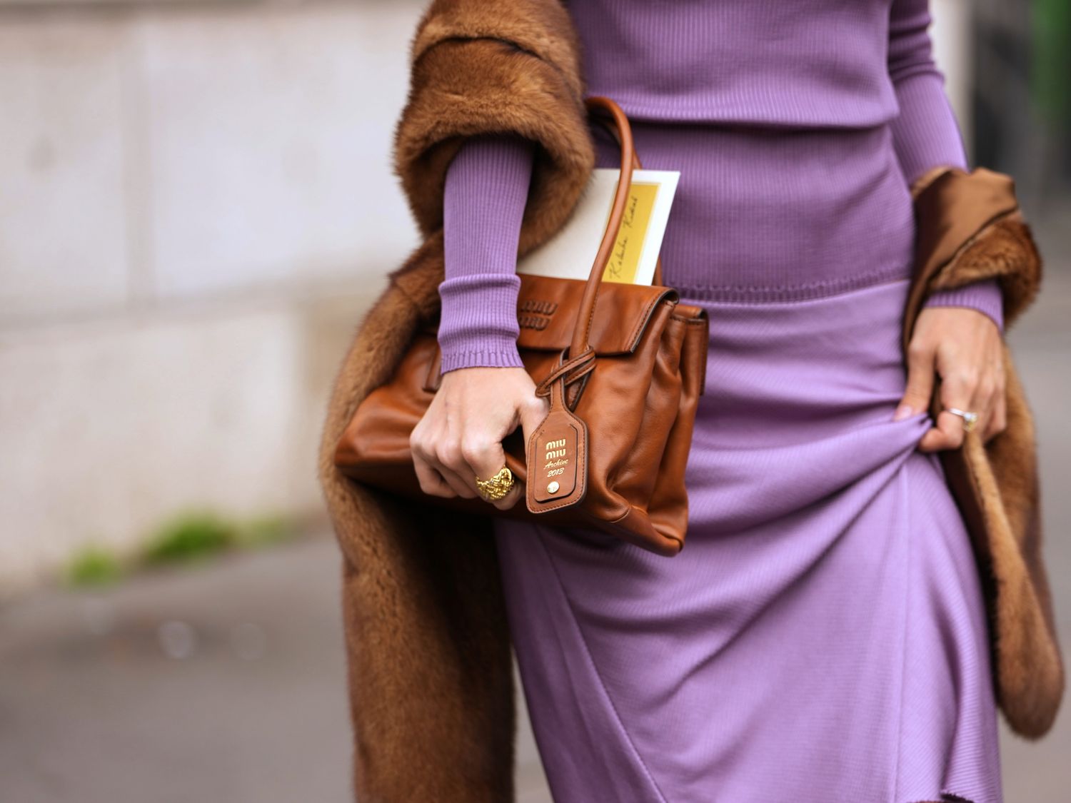 Lilac knitwear, a warm brown coat and a leather bag — colour and texture in the details